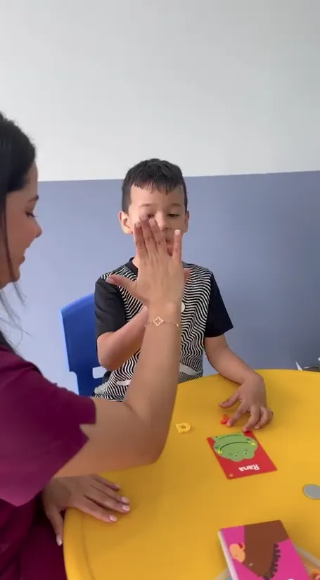 Terapeuta trabajando articulación con un niño en NeuroNexos